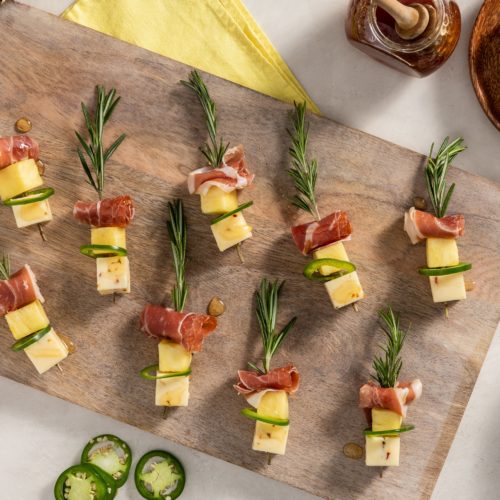 fresh rosemary sprigs skewered with pineapple, prosciutto, jalapeno, and pepper jack cheese and drizzled with honey