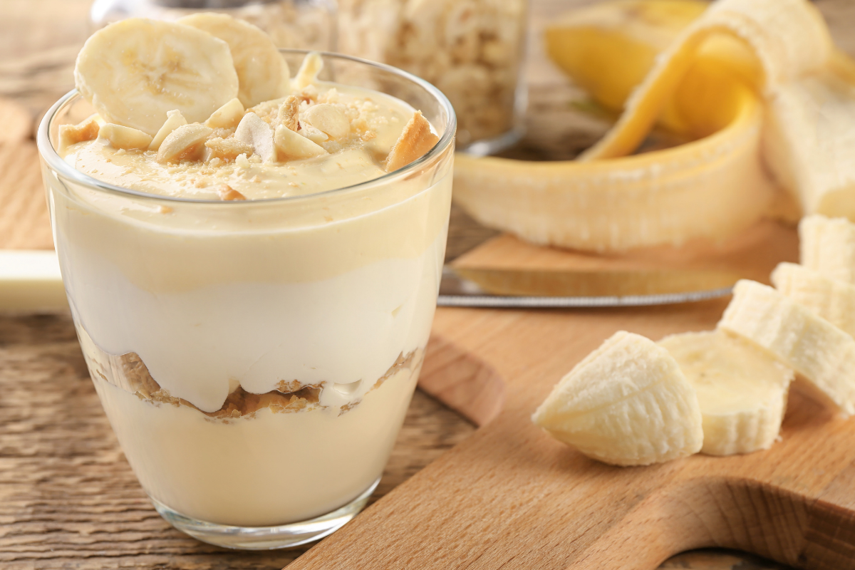 Photo of banana pudding in a glass jar with sliced bananas on top