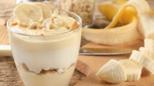 Photo of banana pudding in a glass jar with sliced bananas on top