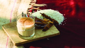 Glass of homemade horchata with ground cinnamon sprinkled on top.