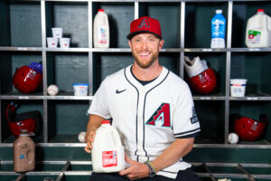 Arizona Diamondbacks pitcher, Merrill Kelly in the dugout holding a gallon of milk