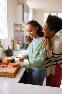 Allowing kids to help with cooking and meal prep to build confidence and independence