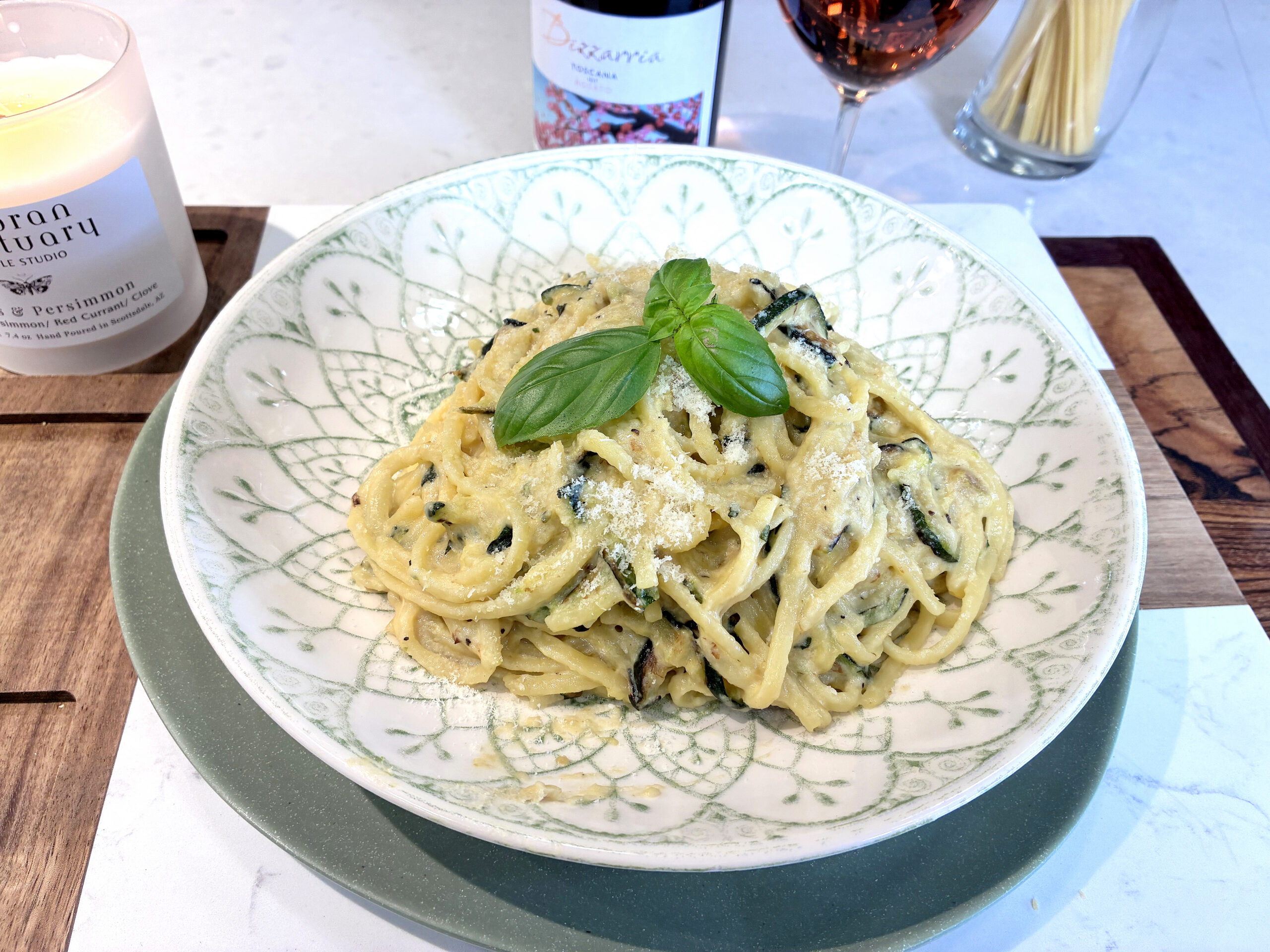 pasta alla nerano in a white bowl with fresh basil garnish