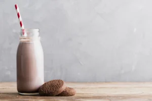 A glass bottle of chocolate milk sitting on a table